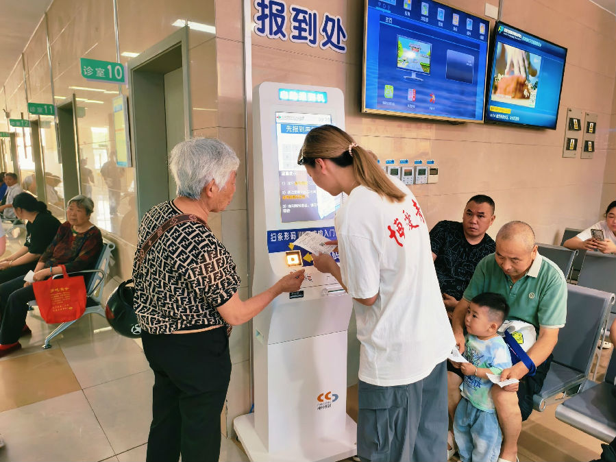 图为志愿者指导老人使用自助机器.jpeg